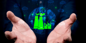 Manos abiertas sostienen un concepto digital de fábricas con hojas verdes, simbolizando el compromiso industrial con la sustentabilidad y el respeto por el medio ambiente.