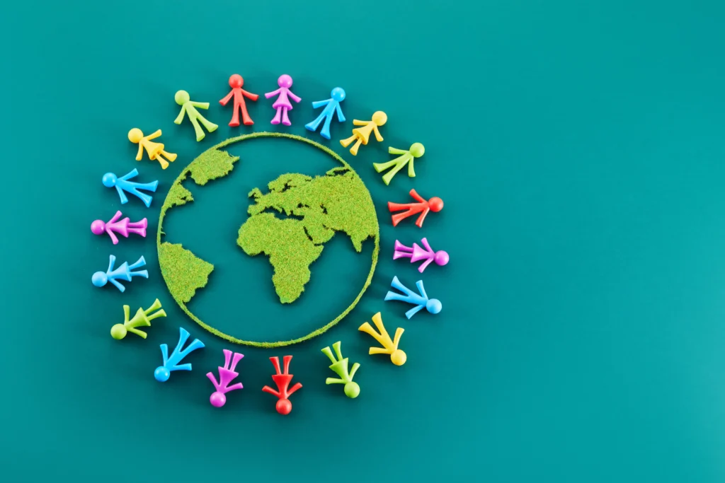 La imagen simboliza la cooperación mundial necesaria para alcanzar los ODS, con personas unidas alrededor del planeta.