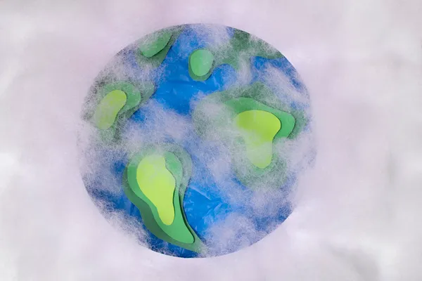 Planeta Tierra con zonas verdes y azules cubiertas de nubes, evocando el papel de la atmósfera en el efecto invernadero.
