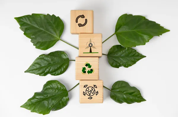 Símbolos de reciclaje, energía y equilibrio ambiental reflejan los valores clave para comprender cómo mejorar mi calificación en Ecovadis dentro de una gestión sostenible.