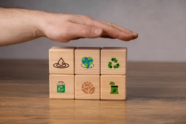 Cubos de madera de cuidado ambiental, reflejando el tipo de valores que ayudan a distinguir cuáles son las diferencias entre EcoVadis y el Distintivo ESR.
