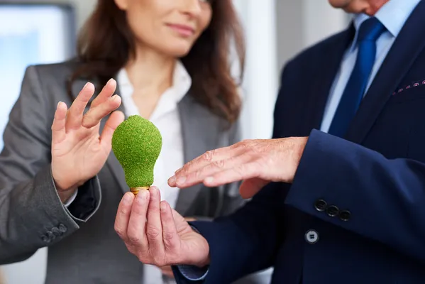 Profesionales sostienen un símbolo verde que representa la conexión entre ética empresarial y sostenibilidad, eje central de las NIS A1 y B1 emitidas por el CINIF en México.